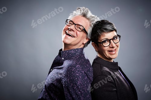 Preview: Back to back studio portrait of mature businessman and woman
