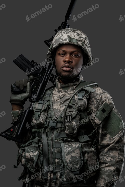 Preview: Armed black soldier with rifle looking at camera