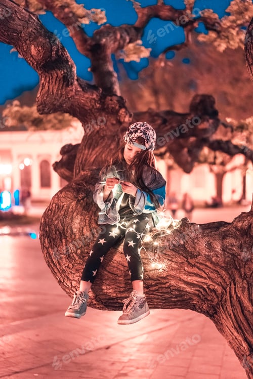 Preview: preschool girl sitting on a tree branch