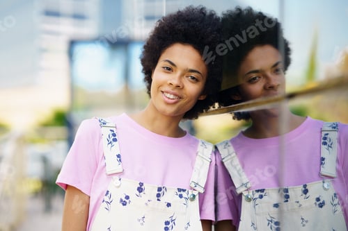 Preview: Optimistic African American woman in casual clothes looking at the camera smiling.