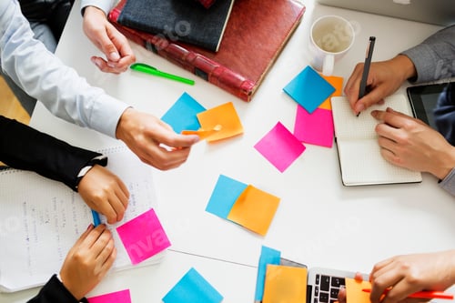 Preview: Team brainstorming with colorful sticky notes on a white table.