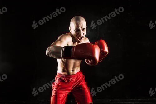 Preview: Aggressive Man Boxing with Red Gloves in Studio