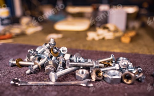 Preview: Metal nuts bolts and a wrench lie on the work table of the assembler