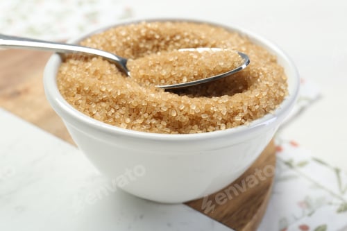 Preview: Brown sugar in bowl and spoon on table, closeup