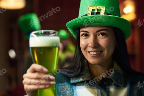 Preview: Focus on young smiling brunette woman with glass of green beer