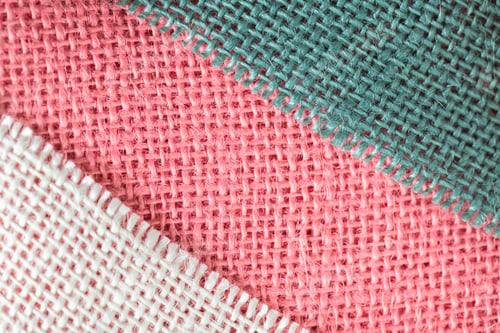 Preview: Close up background, bright delicate pink, beige and blue fabric texture, thread weave, textile