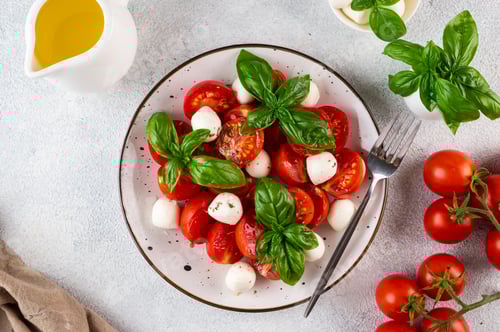 Preview: Italian caprese salad with sliced tomato, mozzarella, basil, olive oil. Italian food. Healthy salad