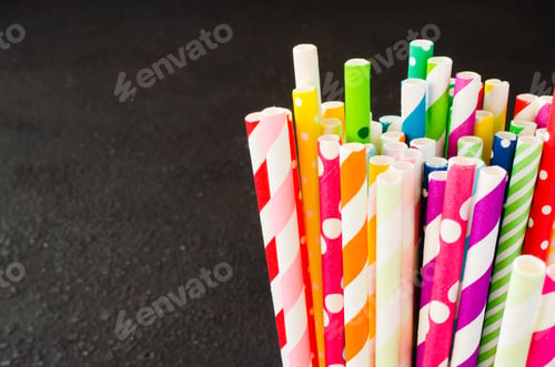 Preview: Colorful paper straws of different colors for cocktails and drinks on dark background.