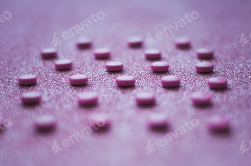 Preview: Pink pills, medicine isolated on glittery pink background.