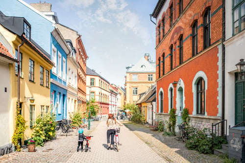 Preview: Mother and daughter walking with bicycles in city