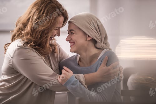 Preview: happy mother and sick adult daughter in kerchief hugging and looking at each other