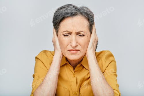 Preview: Headache, stress. Mature woman with headache touching hands on temples with suffering facial and