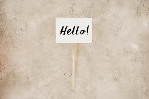 Preview: top view of hello lettering on placard on concrete surface