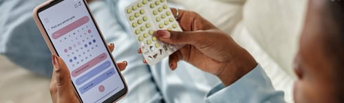 Preview: Young Black Woman Checking Birth Control Pills Using Smartphone App