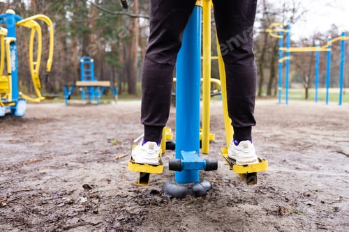 Preview: men's legs on an outdoor metal simulator that imitates walking. Outdoor sports. Municipal sports gro