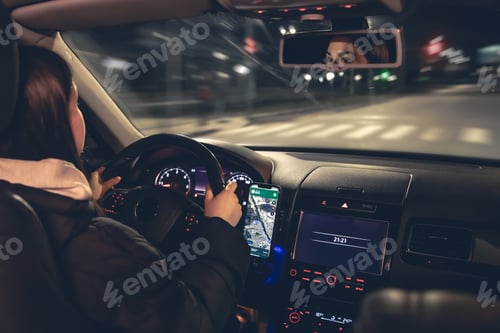 Preview: Driving a car at night, a woman driving her modern car at night in the city.