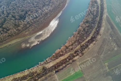 Preview: Aerial view of wide river flowing quietly in rural countryside in autumn evening