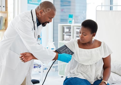 Preview: Mature doctor checking the blood pressure of a patient. African american doctor applying blood pres
