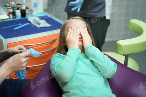 Preview: Little scared girl sitting in chair in dentist doctor office. Kid,child afraid of tooth
