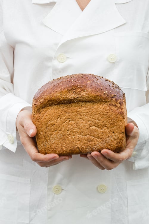 Preview: Baker holding fresh bread in the hands of