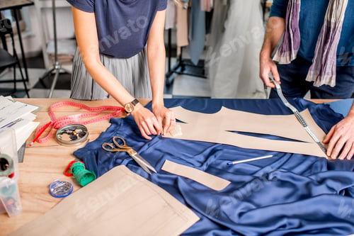 Preview: Tailors cutting blue fabric on the table