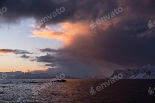 Preview: Dramatic sunset over snowy mountains and sea