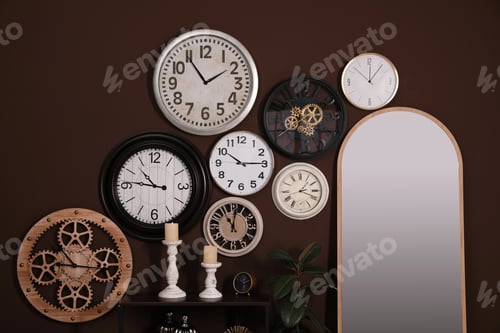 Preview: Mirror and collection of clocks on brown wall indoors