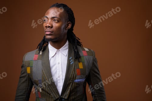 Preview: Young handsome African businessman against brown background