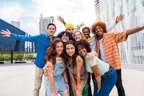 Preview: Happy playful multiethnic group of young friends bonding outdoors