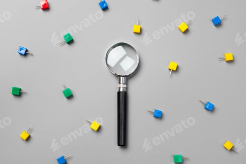 Preview: magnifying glass with paper clips on grey background.minimalism concept