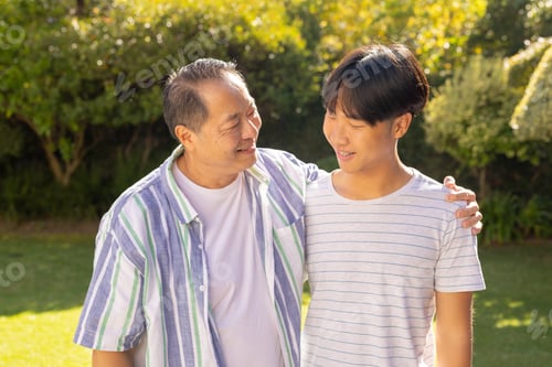 Preview: asian father and son bonding outdoors, smiling and enjoying time together