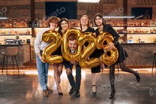 Visualização: Grupo de pessoas com lindas roupas elegantes estão comemorando o Ano Novo em ambientes fechados juntos