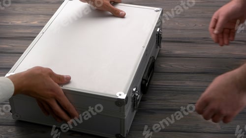 Preview: Close-up man with silver metal briefcase.