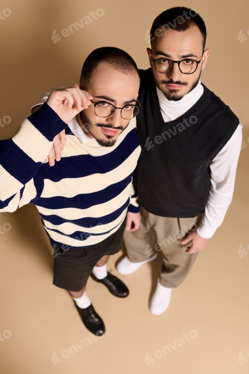 Preview: Stylish twin brothers showcase their fashion sense in a trendy indoor setting