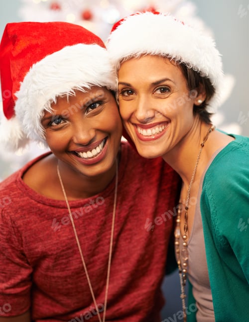 Preview: Santas little helpers. A portrait of two happy best friends wearing santa hats at Christmastime.