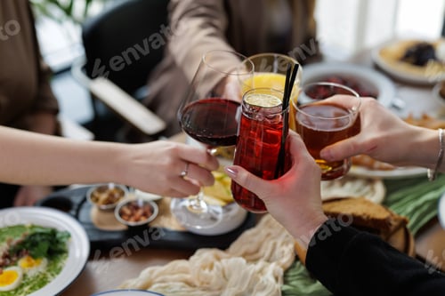 Preview: Friends Toasting Wine and Cocktails at Dining Table Celebration