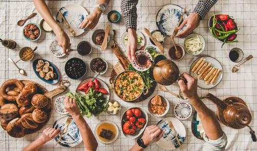 Preview: Flat-lay family having traditional Turkish breakfast over chekered tablecloth