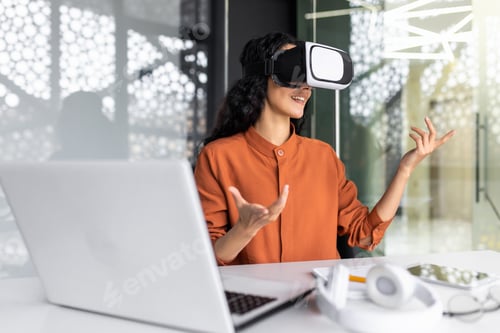Preview: Successful latin american woman in office using vr glasses for video call and chatting online in