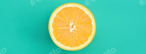 Preview: Top view of a one orange fruit slice on bright background in turquoise green color