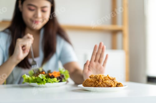 Preview: Young girl rejecting junk food or unhealthy food such as fried chicken by pushing dish