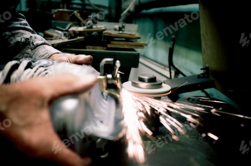 Preview: Cropped image of worker's hands sharpens the blades on skate in workshop