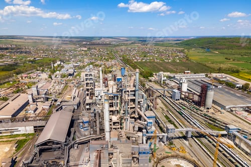 Preview: Aerial view of cement plant with high concrete factory structure and tower crane at industrial