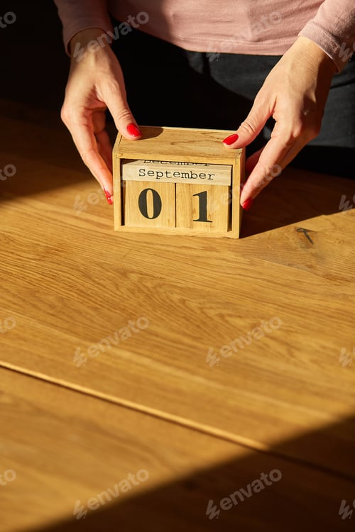Preview: Woman hand change, sets the date on the wooden calendar on 01 Janyuary