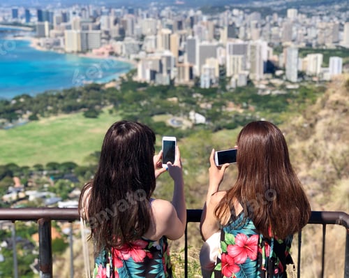 Preview: Two millennials matching outfits Tourists Taking photos of Waikiki at the top of diamond head hike