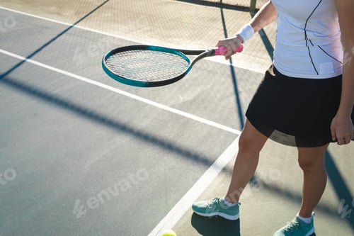 Preview: Low section of young female caucasian player playing at tennis court on sunny day