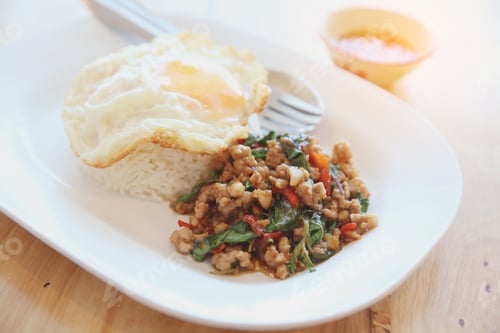 Preview: Stir Fried Pork And Basil With Rice And Egg On Wood Background Thai Food
