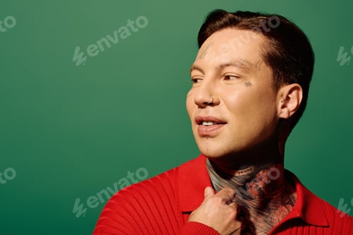Preview: A young man with tattoos poses against a vibrant green backdrop during a creative photoshoot