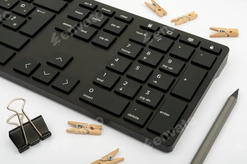 Preview: Closeup of a computer keyboard with office stationery on a white background