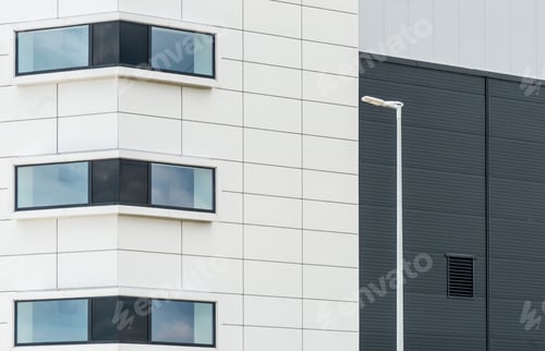 Preview: Black and white facade of a building with the windows reflecting the sky
