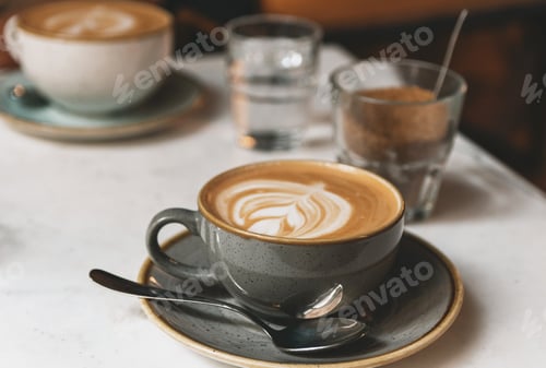 Preview: Cup of coffee with latte art on table in cafe